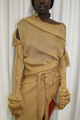 Nuori nainen, jonka kasvoja ei näy, seisoo voittoisan malliston vaatteet yllään ja katsoo kameraan