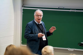 An man having a presentation and standing in front of an audience