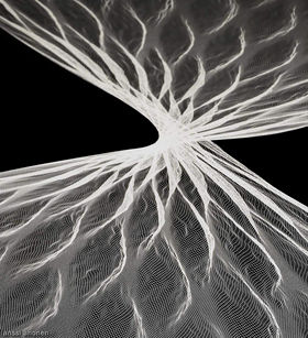 White, net-like twisted textile on a black backround