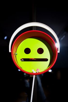 A red bucket with a green neutral face inside