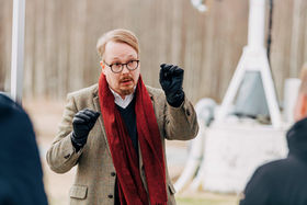 Tutkija kertomassa yleisölle ulkona sijaitsevista satelliiteista.