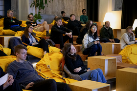 Audience sitting on bright yellow beanbag chairs.