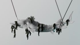 A white shark caught in chains while algae grow out of it, 3D render
