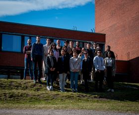 21 people standing on the grass