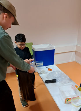 photo showing a young child holding a plastic bag with ice cream mis