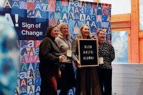 Alumnit kuvausseinällä