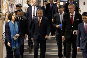 En grupp människor i affärskläder går nerför trappan. Några bär dokument och andra har slipsar i olika färger.