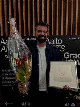 A person holding a bouquet of flowers and a framed artwork. Background has text related to Aalto ARTS.