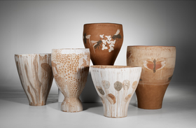 Five large ceramic pots with various floral and insect designs, displayed against a grey background.