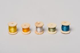 Five wooden spools with threads in yellow, orange, silver, green, and blue, arranged in a row on a light background.