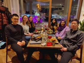 Group members having dinner facing the camera