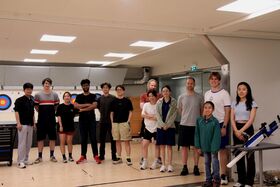 Groups of interns doing archery 