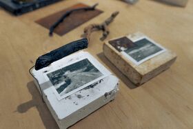 Two blocks with photos on top, one white and one beige, with a black object attached to the white block.