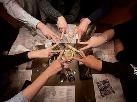 Ystävät ruskean pöydän ääressä muodostavat sormilla tähden valikkojen ja juomien yllä