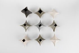 Nine hollow, star-shaped metal cones in grey and beige arranged in a grid on a white background