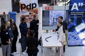 Opiskelijaryhmä esittelee prototyyppiä kahdelle vieraalle Aalto-yliopiston Design Factoryssa