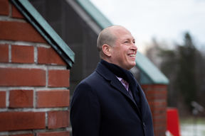 Juha Siivola hymyilee, kuvattu sivulta