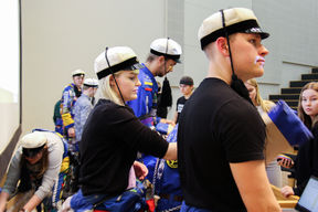 An image of students with blue overalls and Janika Hart