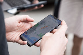 Hands holding a smartphone that displays a map application