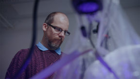 Photo of Juha Koivisto leaning over an experiment
