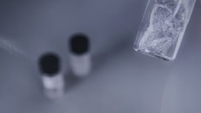 Some ice cube like material in the front, two testing tubes in the backround 