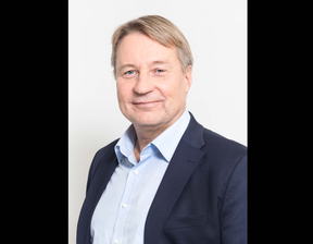 Mobidiagin toimitusjohtaja Tuomas Tenkanen hymyilee kameralle, yllään sininen puku.