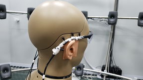 Muovinen tutkimuksessa käytetty pää, johon on kiinnitetty mikrofoni.