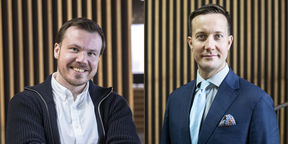 Kaksi miestä katsoo hymyillen kameraan