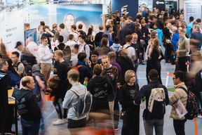 Crowd of people networking at a career fair.