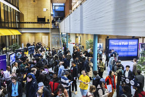 People networking at a career event inside a lobby area.