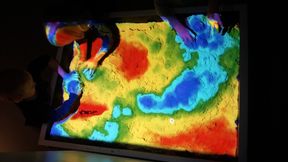  Children playing with augmented reality sandbox.