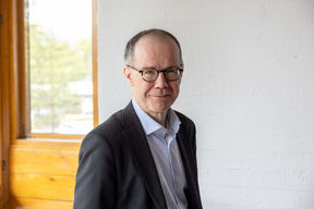 Heikki Mannila standing in front of window