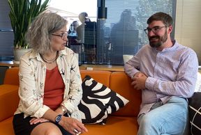 Sophie Belanger on the left and Ferdinand Keil on the right sitting on a sofa  and chatting 