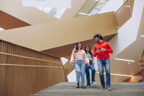 Aalto students walking down the stairs of Aalto University School of Business.