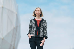 Talvikki Hovatta with the dome protecting the telescope in the background.