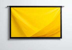 Abstrakti keltainen, laskostuva kangasmainen pinta mustassa kehyksessä vaalealla seinällä