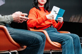 Girl holding a white and blue card that says "Aalto Founder School"