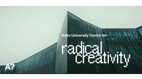 Angular teal building under grey sky with text: Aalto University Centre for radical creativity