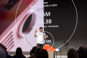 A founder pitching his project on stage in fron of an audience