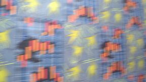 Blurred blue patterned surface with orange blocks and yellow star shapes in motion