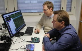 Part of the Xiphera team where they were located at Aalto Startup Center. Two men on the right, sitting, looking at a computer monitor on the left.