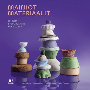 Mainiot materiaalit -kirjan kansi. Materiaalinäytteitä pinottuina torneiksi violetilla taustalla. 