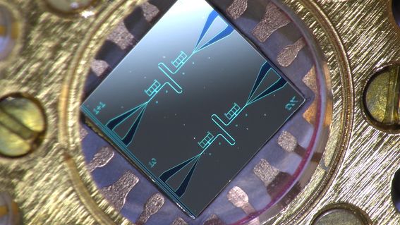 Photo of a centimeter-sized silicon chip, which has two parallel superconducting resonators and quantum-circuit refrigerators connected to them. Image: Kuan Yen Tan.