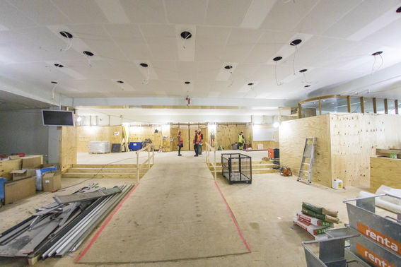 Aalto Töölö main lobby as a construction site, three people standing in the middle while another person works in the corner