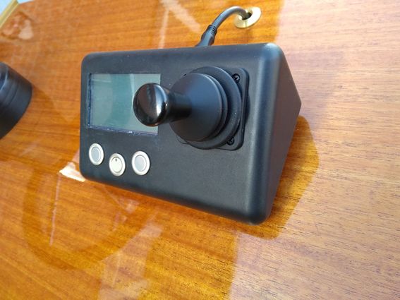 Sähköveneen musta ohjainyksikkö muistuttaa tietokonepeliohjainta, siinä on pieni näyttötaulu sekä kolme nappulaa. Yksikkö on kiinnitetty puiseen lakattuun konsoliin.