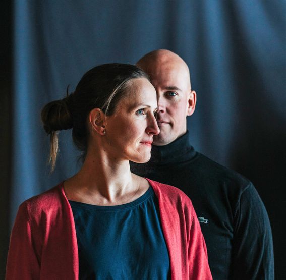 Arnevi Rautanen etummaisena ja Juha Utriainen hänen takanaan tummasävyisessä muotokuvassa, taustalla sininen verho. 