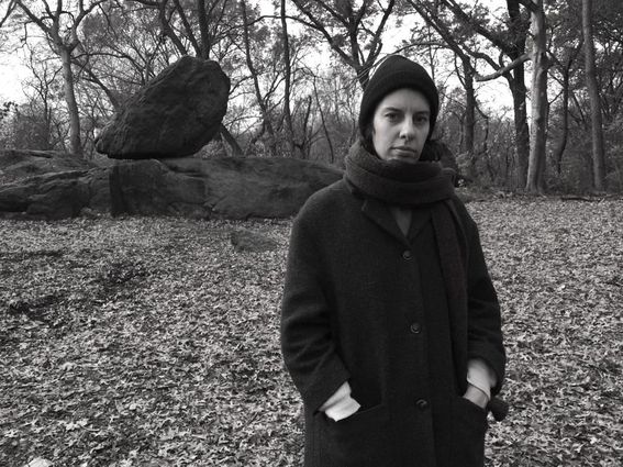 Image of Gloria standing over an autumn background with a rock that has an executive air to it in the background.