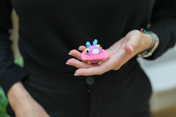 Handmade amulet, a colourful planet-shaped creature with horns.