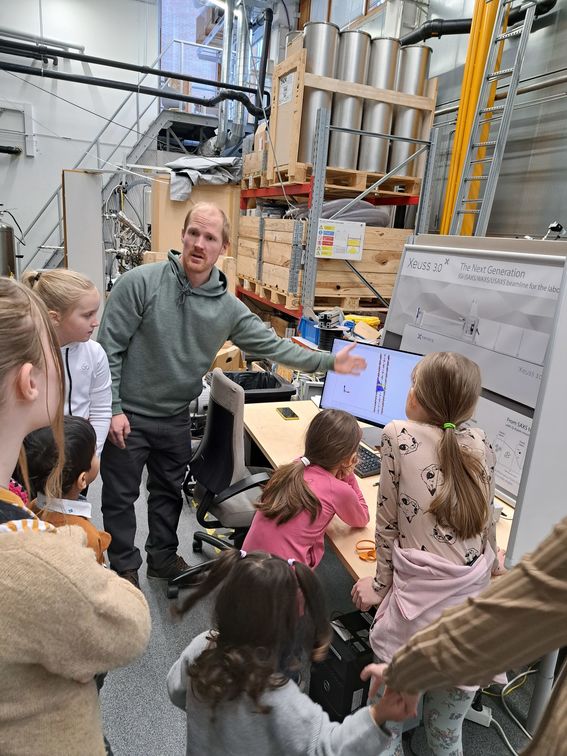A man showing a group of children a computer screen