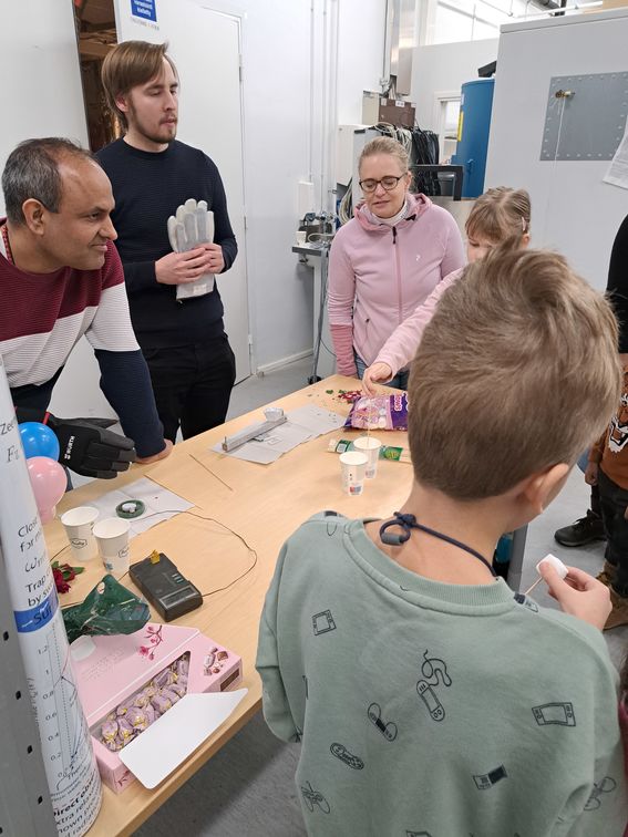 Two men standing at a table with children